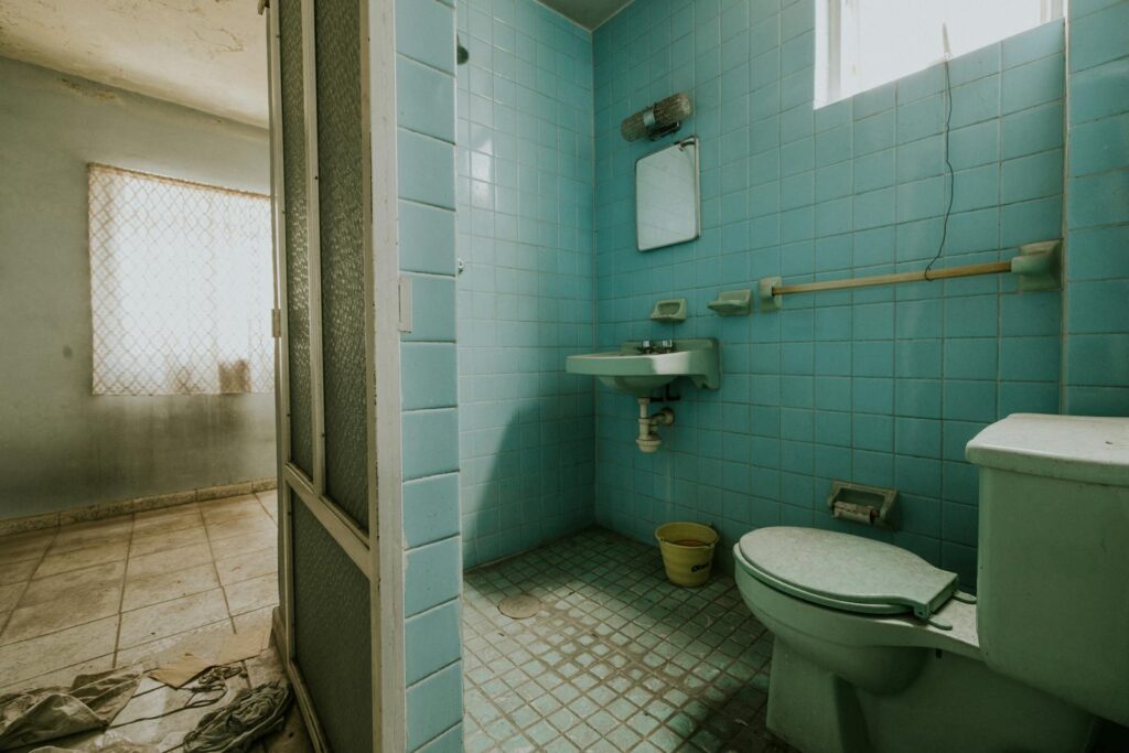 View of a Bathroom and Part of a Room in an Abandoned Dirty House