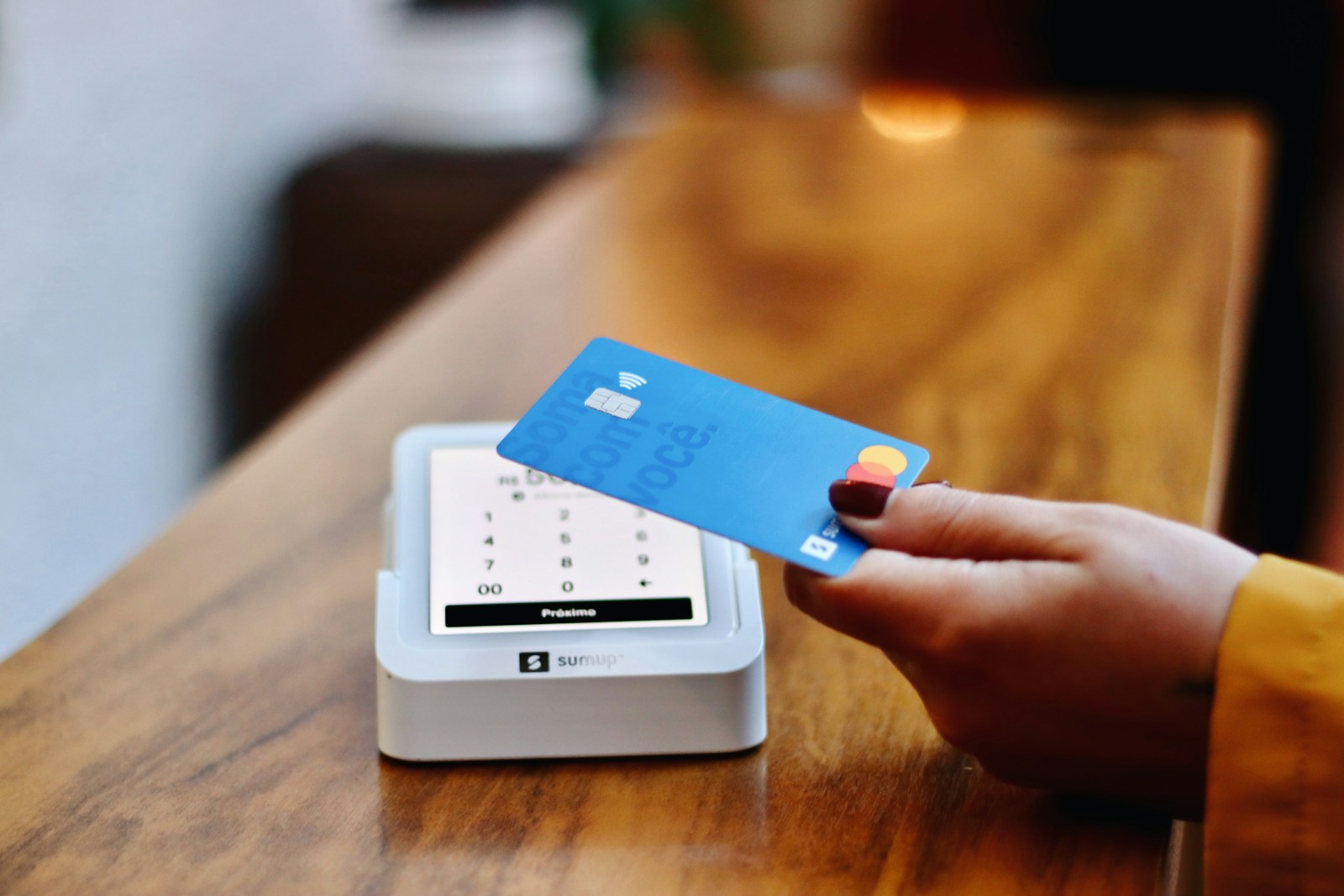 a person holding a credit card in front of a machine